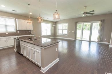 Kitchen featuring ceiling fan, open floor plan, a kitchen island with sink, white cabinetry, and recessed lighting