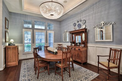 Such a gorgeous warm and inviting Formal Dining room complete with a fabulous unique chandelier, tray ceiling, crown molding, chair rail accent half wall and wood floors.