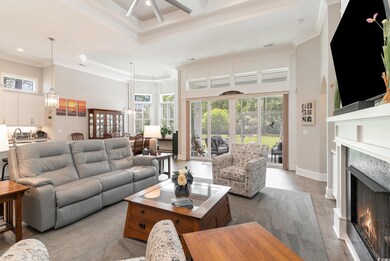 Living room featuring ceiling fan, crown molding, 