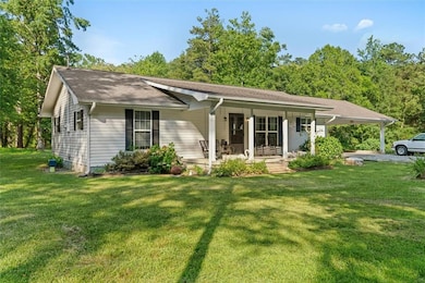 Ranch-style home with a front lawn, a carport, and a porch