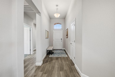 Doorway featuring wood finished floors and a textured wall