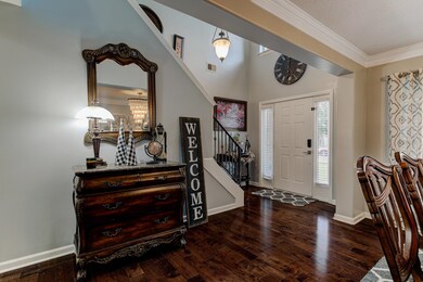 Entryway with a towering ceiling, crown molding, a