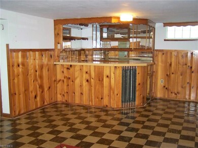 Knotty pine recreation room with built-in bar.