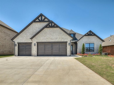 French country style house featuring driveway, brick siding, a garage, and a front lawn
