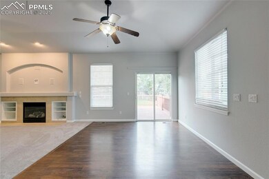 Unfurnished living room with ceiling fan, wood finished floors, and a tile fireplace