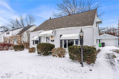 View of front of house featuring an outbuilding, roof with shingles, and a detached garage