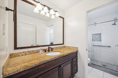 Updated primary bathroom with granite vanity, fram