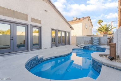 View of pool with french doors, a pool with connected hot tub, and a patio