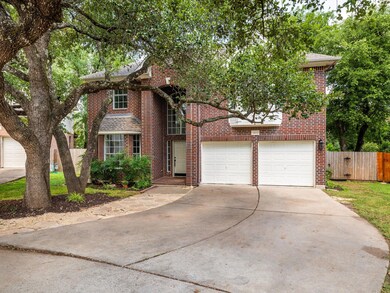 Traditional home featuring concrete driveway, bri