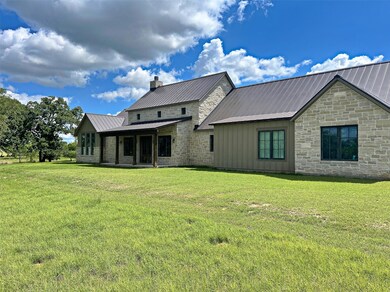 Rear view of property featuring metal roof, board