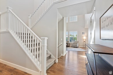 Staircase featuring a high ceiling and wood finished floors