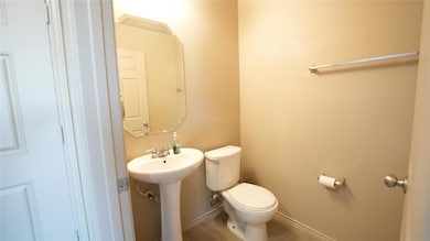 Half bathroom featuring toilet and baseboards