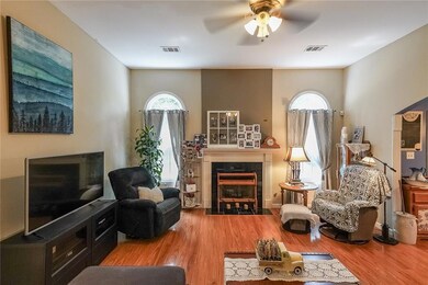 Living area with a fireplace, a ceiling fan, and w