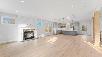 Spacious living area with open concept floor plan.  The gas fire place features custom stone work and trim.