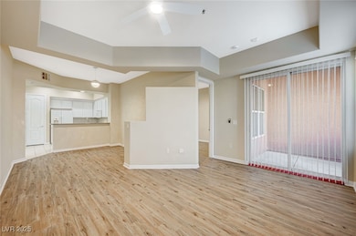 Unfurnished living room featuring lofted ceiling, visible vents, a ceiling fan, baseboards, and light wood-type flooring