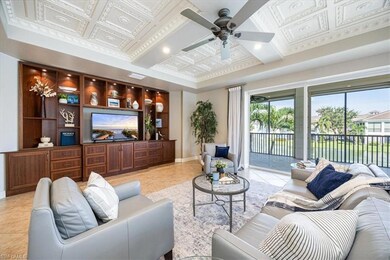 Tiled living room with ceiling fan and coffered ce