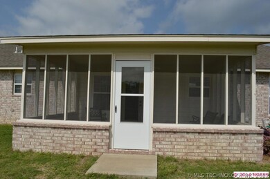 Screened in back patio features storm door.