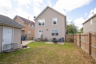 Back of property with a patio area, a yard, and an outdoor firepit