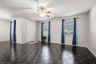 Spare room with plenty of natural light, a ceiling fan, and a textured ceiling
