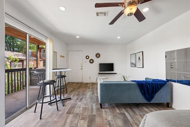 Living area with ceiling fan, wood finished floor