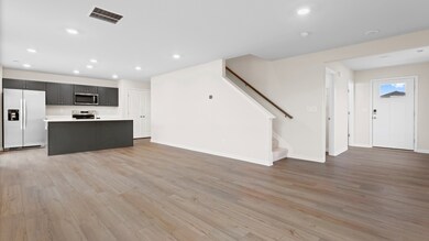Open 1st floor living room and kitchen in a DRB Homes Glenshaw plan at The Village of College Park.