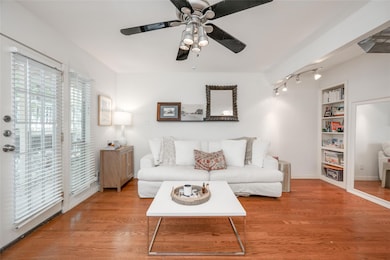 Living room with wood finished floors, built in features, and a ceiling fan