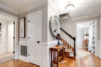 Welcoming foyer with hardwood floors and staircase