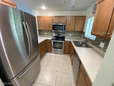 Kitchen with light tile patterned flooring, applia