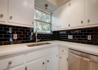 Kitchen with backsplash, dishwasher, light counte
