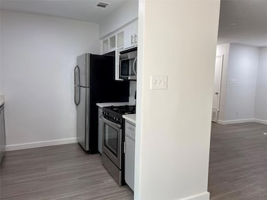 Kitchen with stainless steel appliances, light wo