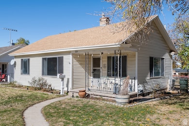 Bungalow featuring covered porch, a chimney, and roof with shingles