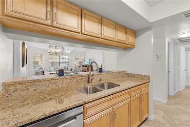 Kitchen featuring light stone counters, a sink, vi