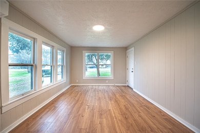 Spare room with a textured ceiling, light wood fin