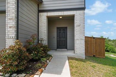 View of exterior entry with brick siding and fence