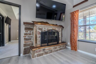 Detailed view of a stone fireplace and wood finished floors