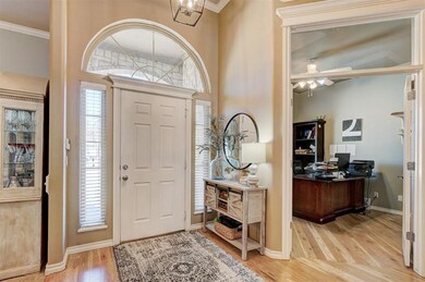 Foyer entrance with crown molding, a ceiling fan, light wood-type flooring, and baseboards
