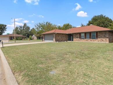 Ranch-style house with brick siding, a front yard, a shingled roof, driveway, and an attached garage