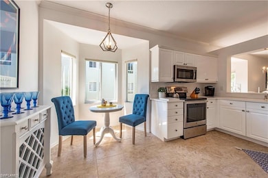 Kitchen featuring hanging light fixtures, white ca