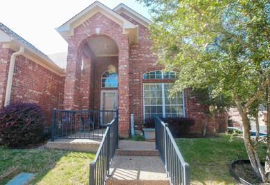 View of exterior entry with brick siding and a yar