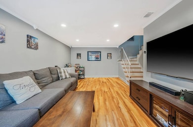 Living room featuring crown molding, recessed lighting, stairway, and light wood finished floors