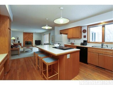 Center island kitchen with hardwood floors extends