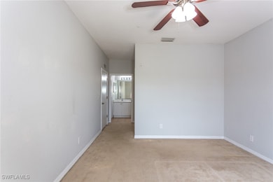 Empty room with light carpet, ceiling fan, baseboa