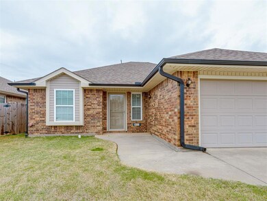Single story home featuring a garage, brick siding