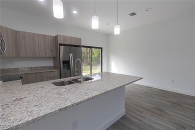 Kitchen with light stone counters, stainless steel