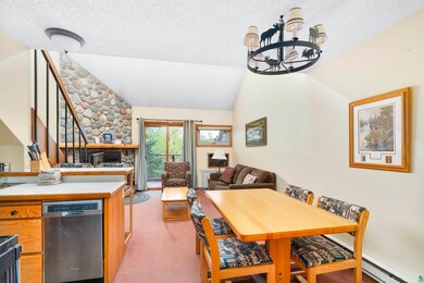 Carpeted dining room with an inviting chandelier, 