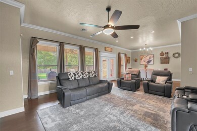 Living room with crown molding, tall ceilings and wood floors.