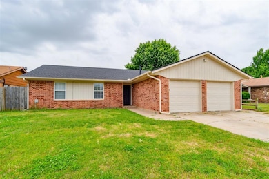 Ranch-style home featuring a garage, driveway, and brick siding