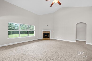 Unfurnished living room featuring carpet flooring, a tiled fireplace, ceiling fan, and high vaulted ceiling