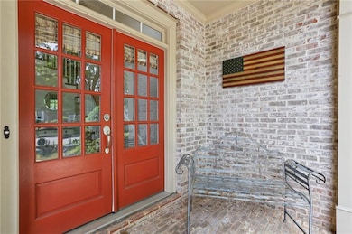 Entrance to property with french doors, brick siding, and a porch
