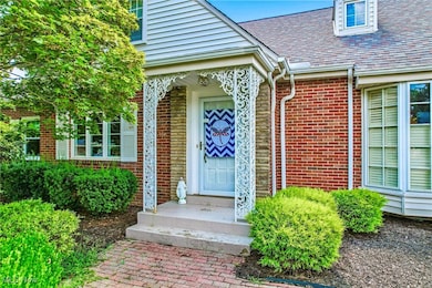 Property entrance featuring brick siding and a shingled roof